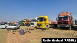 
ډریورانو د ګربزو په صحرا کې عمومي لاره تړلې او یو بل سر کې يې بارداره موټر په څنګو درولي تر څو په لاره موټر تګ او راتګ ونه کړای شي.