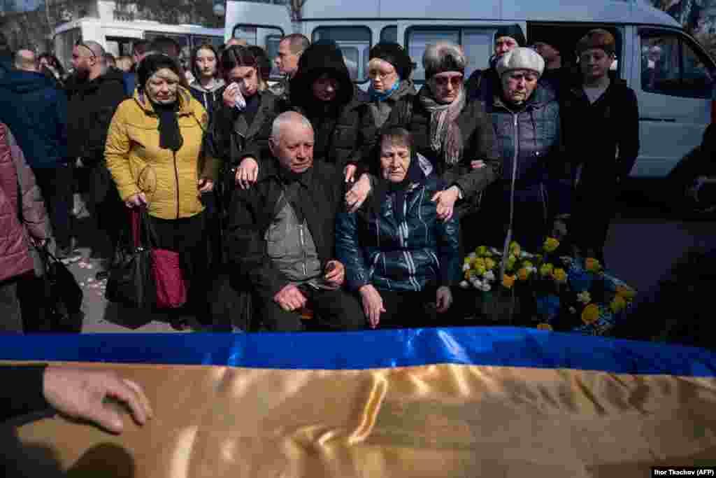 Rođaci tuguju pored kovčega ukrajinskog vojnika koji je nedavno poginuo u borbi, tokom njegove sahrane u Poltavi u centralnoj Ukrajini.