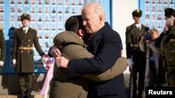 U.S. President Joe Biden (right) embraces his Ukrainian counterpart, Volodymyr Zelenskiy, as they visit the Wall of Remembrance to pay tribute to slain Ukrainian soldiers, in Kyiv on February 20.