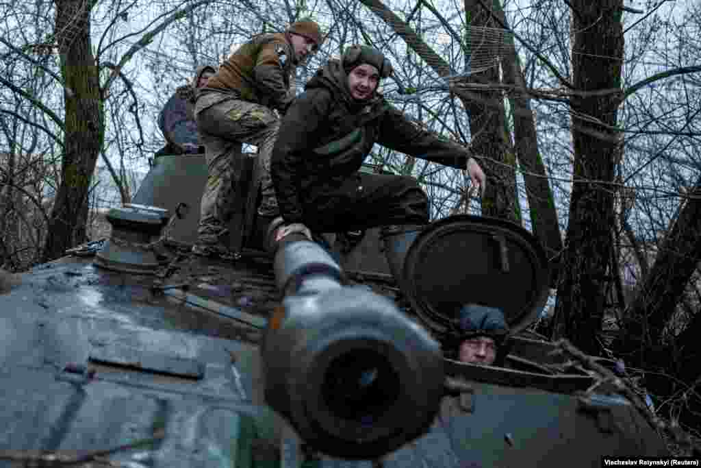 Украинские солдаты садятся на самоходную гаубицу 2С1 «Гвоздика» перед её выходом на огневую позицию