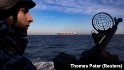 Український морський прикордонник спостерігає за судном, яке вийшло з порту України. Чорне море, лютий 2024 року