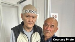 Gazak žurnalisti Duman Mukhammedkarimi (çepde) kakasy Almaz Tilepow bilen kazyýet diňlenişiginde (arhiw suraty)