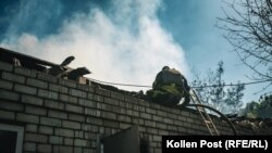Egy tűzoltó vizet fecskendez Viktor, egy harkivi otthonába a beomlott tetőn keresztül