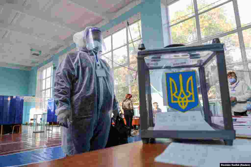 Місцеві вибори 2020-го. 25 жовтня в Україні відбулись вибори до місцевих органів влади. На фото: член виборчої комісії в Слов'янську в засобах індивідуального захисту перевіряє урну на дільниці 