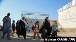 یک خانواده مهاجر افغان که از ایران در حال بازگشت به افغانستان هستند.
