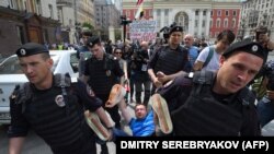 Orsýetiň ýöriteleşdirilen polisiýasy geýleriň hukuklaryny goraýjy Nikolaý Alekseýewi alyp barýar, Moskwa, 30-njy maý, 2015