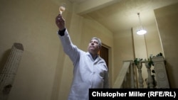 Winemaker Yuriy Ivanovich holds a glass of Artwinery's pink sparkling brut up to the light to show its color in Bakhmut, Ukraine. 