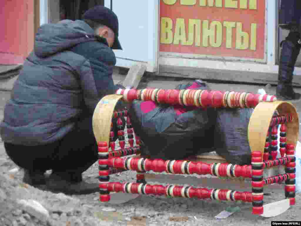Мужчина, собирающийся пересечь границу с Узбекистаном, с деревянным бесиком (колыбелью). 