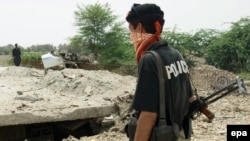 FILE: Pakistani security officials inspect the site of a bomb blast near Dera Ismail Khan.