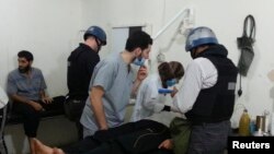 کارشناسان سازمان منع استفاده از سلاح‌های شیمیایی در حال معاینه افرادی که در اثر حملات شیمیایی حکومت سوریه مجروح شده اند.