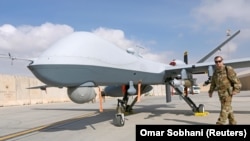 FILE: A U.S. Air Force officer passes in front of a MQ-9 Reaper drone at the Kandahar air base in January 2018.
