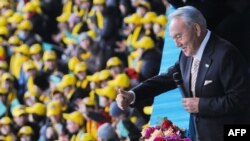 Президент Казахстана Нурсултан Назарбаев приветствует зрителей церемонии празднования Дня первого президента. Астана, 1 декабря 2012 года.