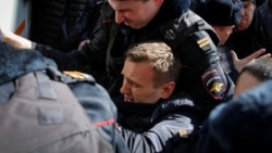 Полицейские затаскивают Алексея Навального в автозак