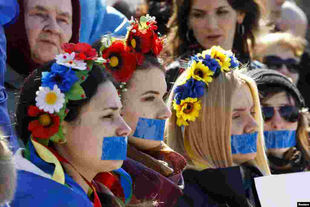 Учасниці акції, представниці руху «Жінки Криму за МИР», провели в Сімферополі мовчазну акцію на підтримку свободи слова. Дівчата заклеїли собі роти синьою стрічкою, а в руках тримали чисті плакати без єдиної літери, 13 березня 2014 року.