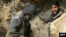 Miners drill into rock in a makeshift mine in northeastern Afghanistan (file photo).