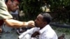 A Libyan rebel combatant slaps a wounded man accused of fighting for Muammar Qaddafi