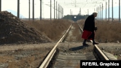 An elderly woman crosses railway tracks near the Armenian village of Yeraskh close to the border with Azerbaijan (file photo)