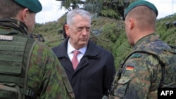 U.S. Defense Secretary James Mattis (center) talks with a German (right) and a Lithuanian soldier as he meets with U.S. troops deployed in Lithuania and other NATO troops on May 10.