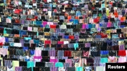 Rochii şi fuste înșirate pe un stadion în Kosovo, în cadrul unei campanii împotriva victimelor abuzurilor sexuale. 12 iunie 2015