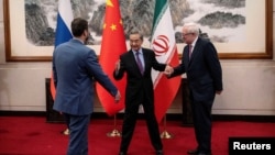Kineski ministar vanjskih poslova Wang Yi (u sredini) pozdravlja zamjenika ruskog ministra vanjskih poslova Sergeja Ryabkova (desno) i zamjenika iranskog ministra vanjskih poslova Kazema Gharibabadija prije sastanka u Pekingu u martu o iranskom nuklearnom programu.