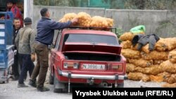 Покупатель грузит мешок картофеля на автомобиль на рынке «Сары-Озон». Бишкек, 11 октября 2018 года. Иллюстративное фото.