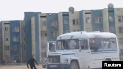 Участник акции протеста бежит от загоревшегося автобуса. Жанаозен, 16 декабря 2011 года.