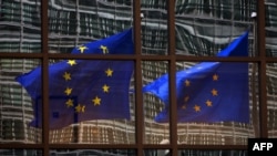 Belgium -- A European flag reflects in a building of the EU headquarters in Brussels, 06Nov2007