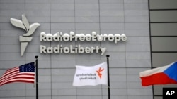 Azat Ýewropa/Azatlyk Radiosynyň Pragadaky baş binasynyň öňünde baýdaklar pasyrdaýar.