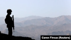 A soldier stands guard along the border fence outside the Kitton outpost on the border with Afghanistan in North Waziristan, Pakistan.