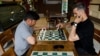 Men play chess at the Cupcake Coffee Shop cafe in Kabul On May 11.