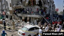 Pakistani troops and rescue workers look for survivors in the rubble following the explosion in Karachi on October 21.