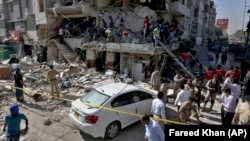 Rescue workers look for survivors in rubble following an explosion at an apartment building in Karachi on October 21.