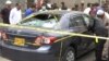 Police and investigators gather around a car used by the attackers in Karachi on June 29.