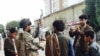 A Taliban fighter (2nd L) poses for a photo at the main square in Kunduz on September 29.